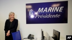 Far-right leader Marine le Pen poses as she inaugurates her campaign headquarters, Wednesday, Nov.16, 2016 in Paris. Far-right leader Marine le Pen is convinced that her anti-immigration, anti-Islam views can lead her to the presidency in five months. 