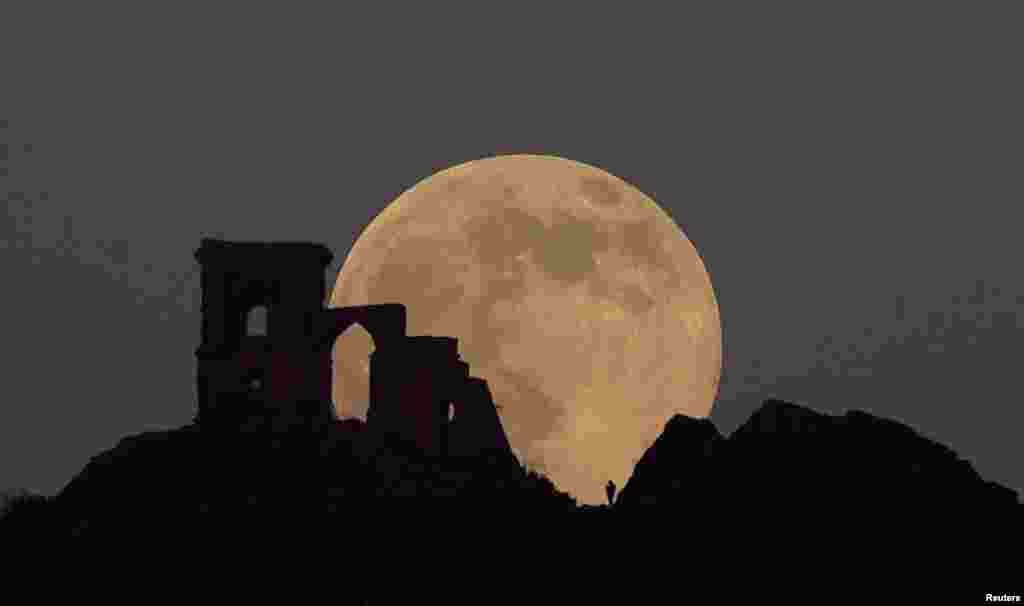 The Wolf Moon rises over Mow Cop Folly, Mow Cop, Britain.
