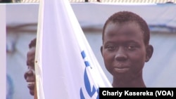 Une jeune réfugiée près d’un drapeau du HCR au cours de la journée Mondiale de Réfugiés à Goma, 20 juin 2017. (VOA/Charly Kasereka)