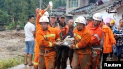 Des pompiers portent sur une civière un blessé après le séisme dans le village Gengdi, à Sichuan, Chine 8 août 2017.
