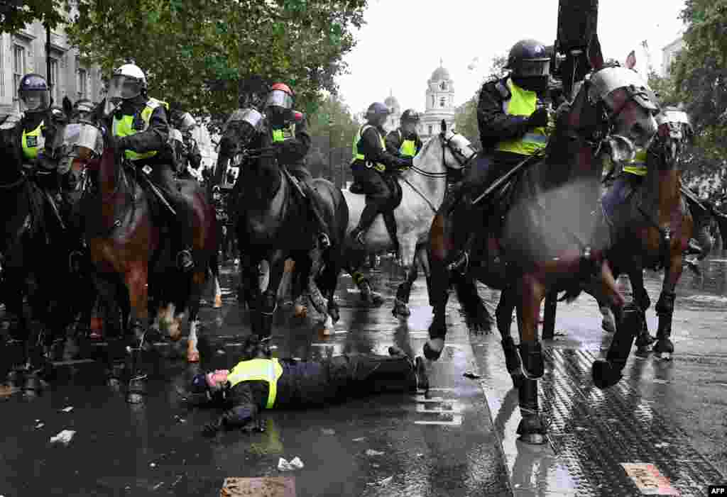 A mounted police officer is seen on the ground after being unseated from his horse, during a demonstration on Whitehall, near the entrance to Downing Street in central London, June 6, 2020, to show solidarity with the Black Lives Matter movement in the wake of the death of George Floyd who died in Minneapolis police custody.&nbsp;