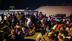 Migrants sit on the ground after being recaptured by Libyan security forces following an escape attempt from a detention facility in the capital, Tripoli, Oct. 8, 2021. Guards shot dead six migrants at the facility, the International Organization for Migration said.