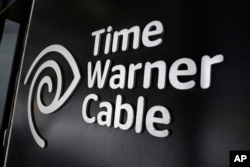FILE - The Time Warner Cable corporate logo is displayed at a company store, in New York, May 26, 2015. U.S. lawmakers are skeptical about the entertainments giant's proposed merger with telecommunications powerhouse AT&T.