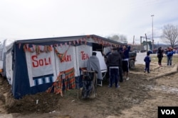 Volunteers have set up a tea-making tent to show solidarity with and bring some "humanity" back into the lives of refugees at the Greek-Macedonian border. (J. Dettmer/VOA)