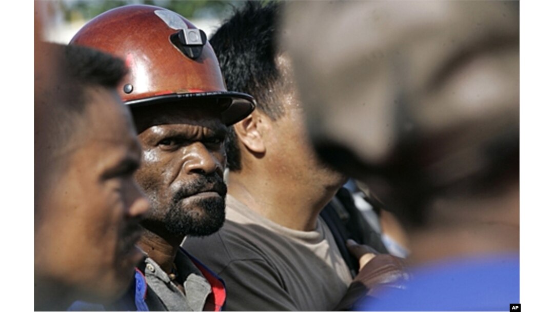 FILE - Freeport McMoRan Copper & Gold Inc.'s workers await bus at Gorong Gorong station in Timika, Papua province, Indonesia, Jan. 3, 2012.