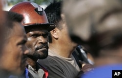 FILE - Freeport McMoRan Copper & Gold Inc.'s workers await bus at Gorong Gorong station in Timika, Papua province, Indonesia, Jan. 3, 2012.