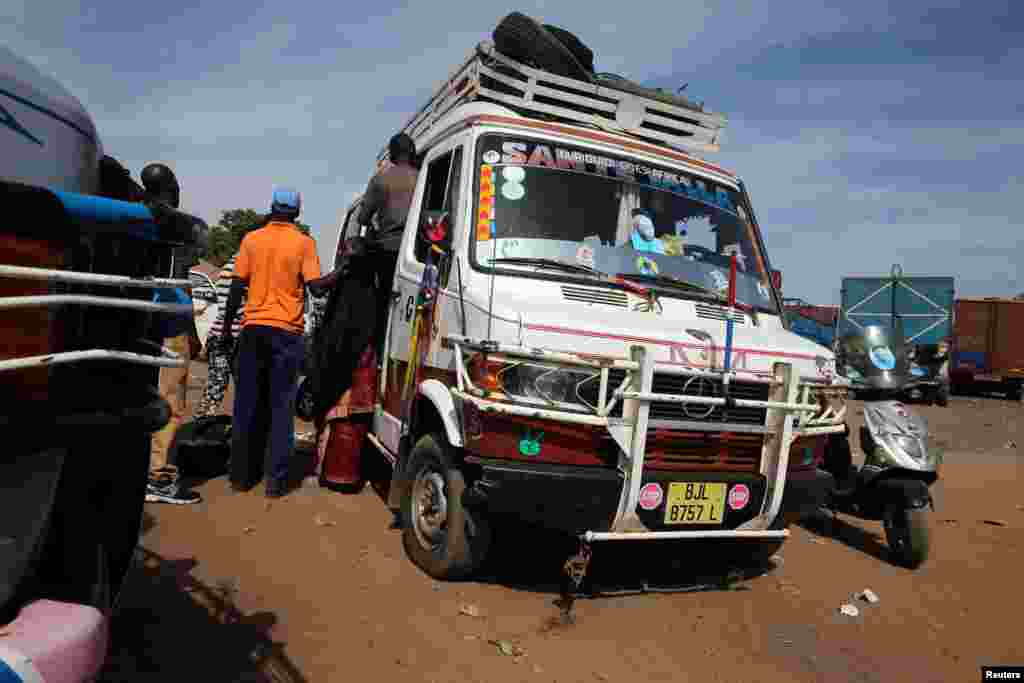 Des passagers montent dans un bus à Serrekunda, dans la capitale gambienne, Banjul, le 17 janvier 2017.