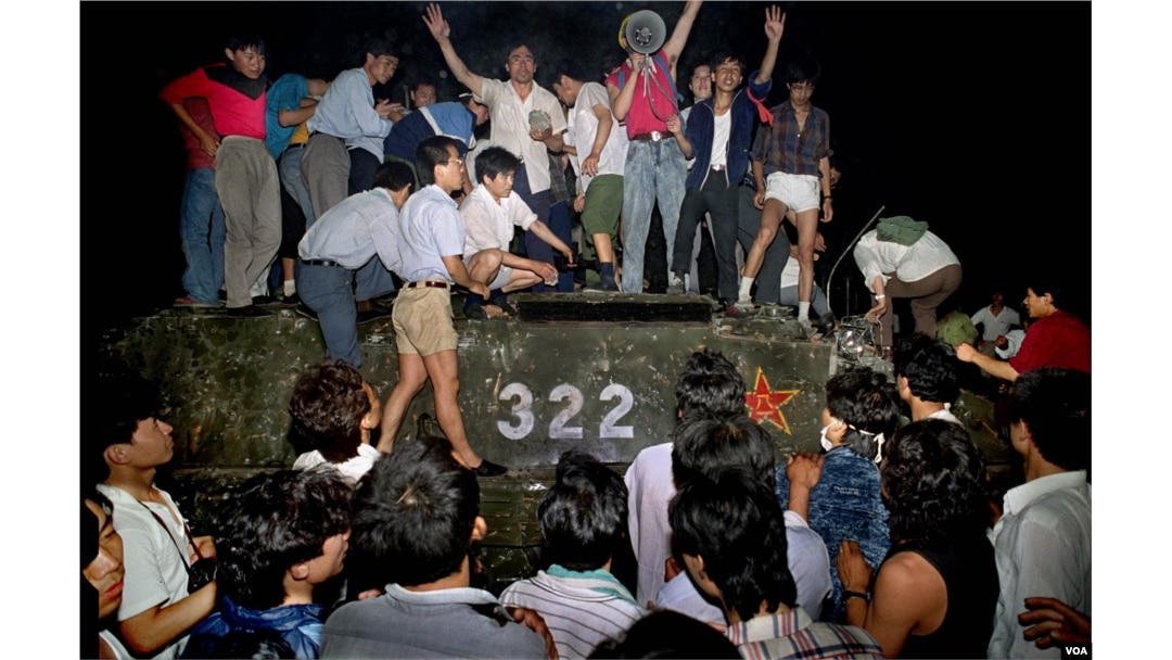 Civili na vladinom oklopnom vozilu u blizini Bulevara Chang'an u Pekingu, 4. juna 1989. Nasilje je eskaliralo između prodemokratskih demonstranata i kineskih trupa, ostavljajući stotine mrtvih preko noći.