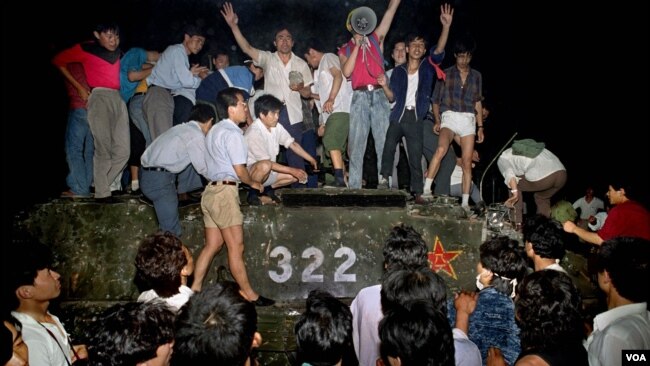 1989年6月4日，北京长安街附近，示威者带着石头登上镇压群众的军队装甲车。 