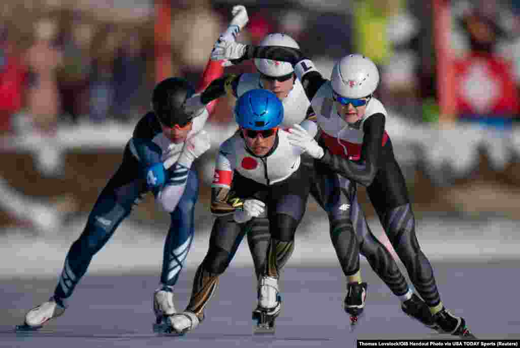 Yuka Takahashi of Japan (C), Sangeon Park of South Korea (L) , Marta Dobrowolska of Poland (R) and Michal Kopacz of Poland (rear C) compete in heat 2 of the Speed Skating Mixed NOC Team Sprint on the St. Moritz Speed Skating Oval during the Winter Youth Olympic Games 2020 in Lausanne, Switzerland.