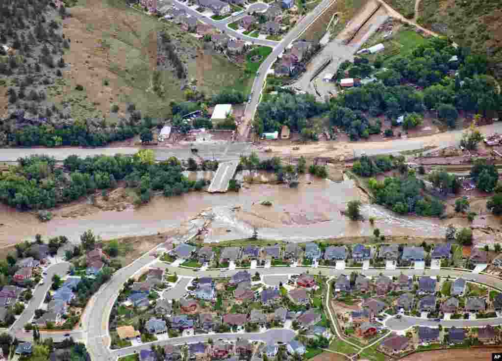 A residential neighborhood and a connecting road in Lyons, Colorado, USA, are cut in two by flood waters as flooding continues to devastate the Front Range, Sept. 13, 2013.