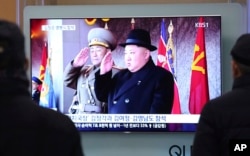 People watch a TV showing North Korean leader Kim Jong Un during a military parade in Pyongyang, North Korea, at Seoul Railway Station in Seoul, South Korea, Feb. 8, 2018.