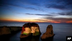 The landmark Raouche sea rock is illuminated by a giant Palestinian flag in Beirut, Lebanon, Saturday, Dec. 9, 2017. Arab countries are condemning the Trump administration's decision to recognize Jerusalem as the capital of Israel with mass protests and other civil society protest actions.