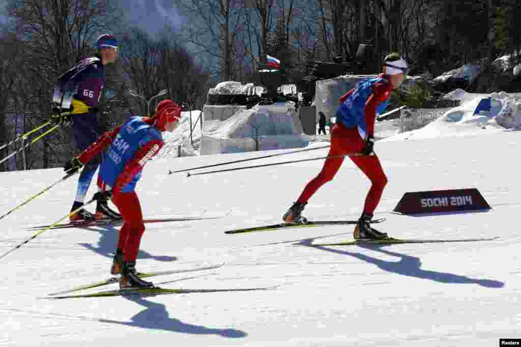 Tim ski Swiss melewati mesin pengisi baterai rudal anti-pesawat dalam latihan di Rosa Khutor, Sochi (6/2).