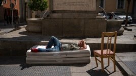 A homeless man sleeps on top of two mattresses in a street in downtown Madrid, Spain, Friday, Aug. 6, 2021. According to reports, poverty has increased considerably in the last months as Spain has been in lockdown to fight the coronavirus pandemic. (AP Photo)