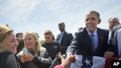 President Barack Obama shakes hands with guests on the tarmac upon his arrival on Air Force One at Groton-New London Airport, May 20, 2015, in Groton, Conn.