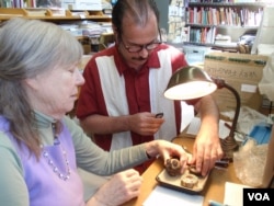 Donor Steven Martin and University of Idaho curator Priscilla Wegars examine and catalogue the donated opium artifacts.(VOA/T. Banse)