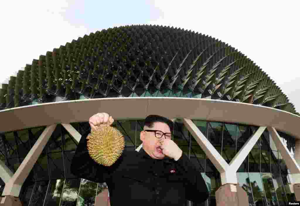 김정은 북한 국무위원장으로 분장한 중국계 호주 배우 하워드가 싱가포르 에스플라네이드 극장 앞에서 열대과일 두리안을 들고 포즈를 취했다.