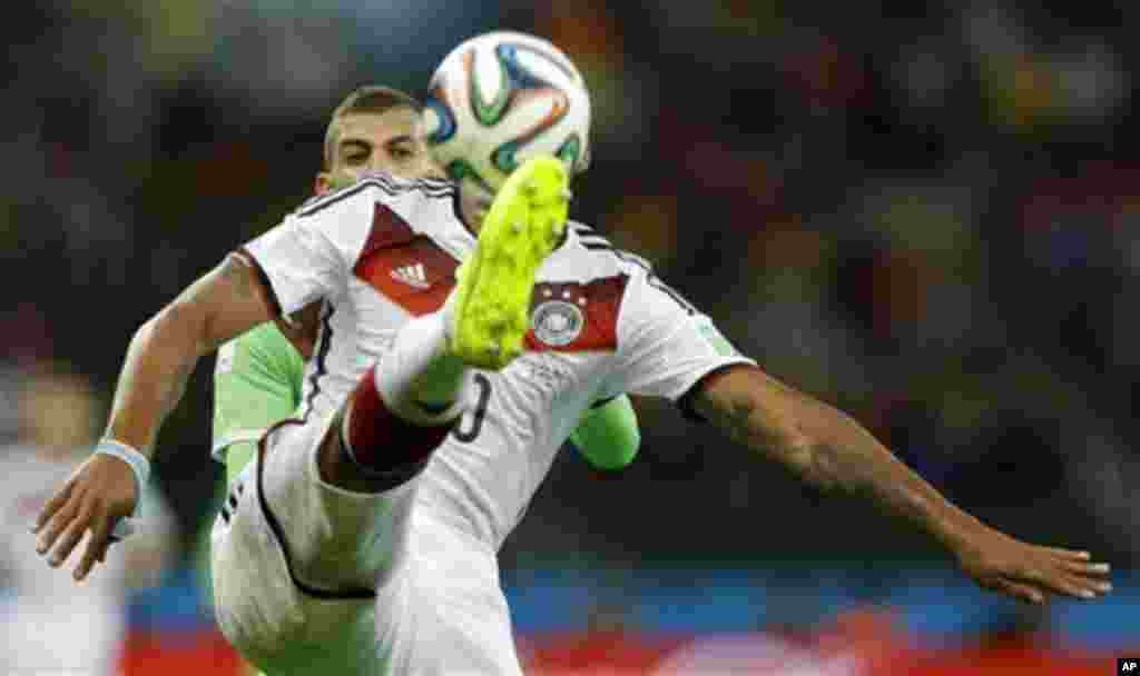 Germany's Jerome Boateng, right, clears the ball away from Algeria's Islam Slimani during the World Cup round of 16 soccer match between Germany and Algeria at the Estadio Beira-Rio in Porto Alegre, Brazil, Monday, June 30, 2014. (AP Photo/Kirsty Wigglesw