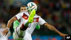 ဂျာမနီ အသင်းက Jerome Boateng (ယာ) အယ်လ်ဂျီးရီးယားက Islam Slimani ဆီက ဘောလုံးကို ဖျက်ထုတ်နေစဉ်။ (ဂျွန် ၃၀၊ ၂၀၁၄)