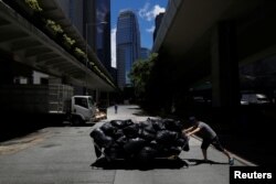A worker pushes a cart loaded with garbage collected nearby to a refuse collection point at the financial Central District in Hong Kong, China, June 7, 2017.