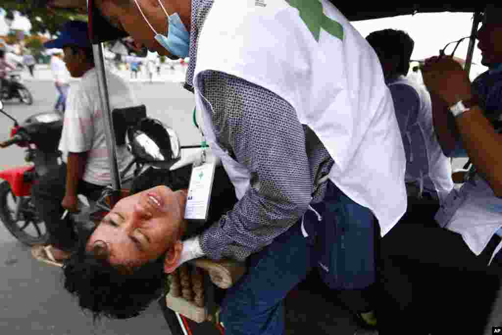 An injured protester of Cambodia's opposition party is carried to a hospital near the Royal Palace in Phnom Penh, Sept. 15, 2013.
