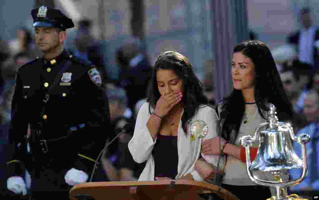 Seorang perempuan tak mampu menahan tangis saat membacakan nama ayahnya yang tewas dalam peristiwa 11 September. Keluarga dan kerabat berkumpul setiap tahunnya di lokasi serangan di Ground Zero, New York (11/9).