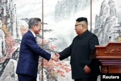 문재인 한국 대통령과 김정은 북한 국무위원장이 19일 평양공동선언문에 서명한 뒤 가진 공동 기자회견에서 악수하고 있다. 평양사진공동취재단.