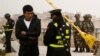 پلیس چین مدارک یک مرد جوان اویغور را بررسی می کند.