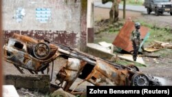 ARCHIVES - Un soldat camerounais à côté d'une voiture calcinée à Buea, en zone anglophone.