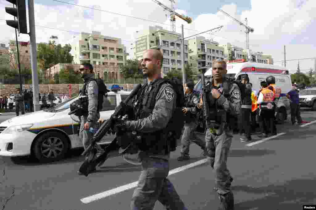 Israeli police officers approach the scene of an attack in Jerusalem, Nov. 5, 2014. 