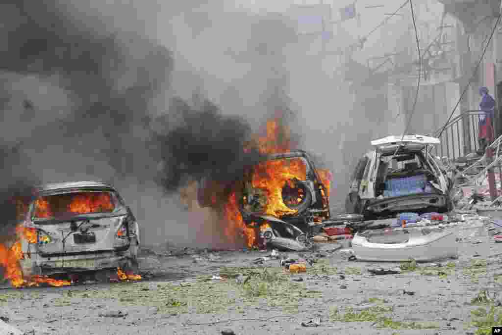 Deux voitures brûlent après un attentat, à Mogadiscio, Somalie, le 30 juillet 2017.