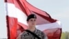 Латвийский солдат с национальным флагом
