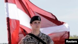 Латвийский солдат с национальным флагом