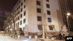 Rescue workers search through rubble outside the Marshal Hotel in Hualien, eastern Taiwan early February 7, 2018, after a strong earthquake struck the island.