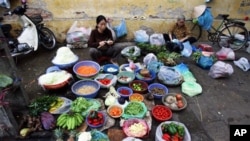 Vietnamese women gather to sell vegetables at a street market , in Hanoi. Vietnam's economy has braced market reform, but the recent boom may be facing some hard times (FILE).