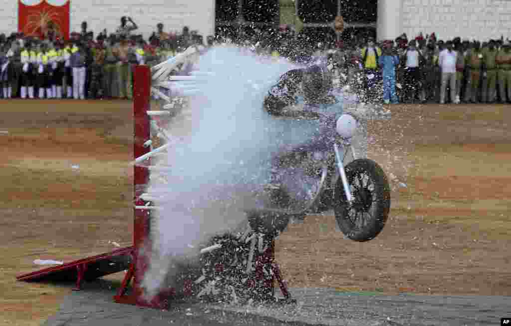 A member of ASC Tornados, the Indian army's motorcycle display team, performs a stunt during Indian Independence Day celebrations in Bangalore.