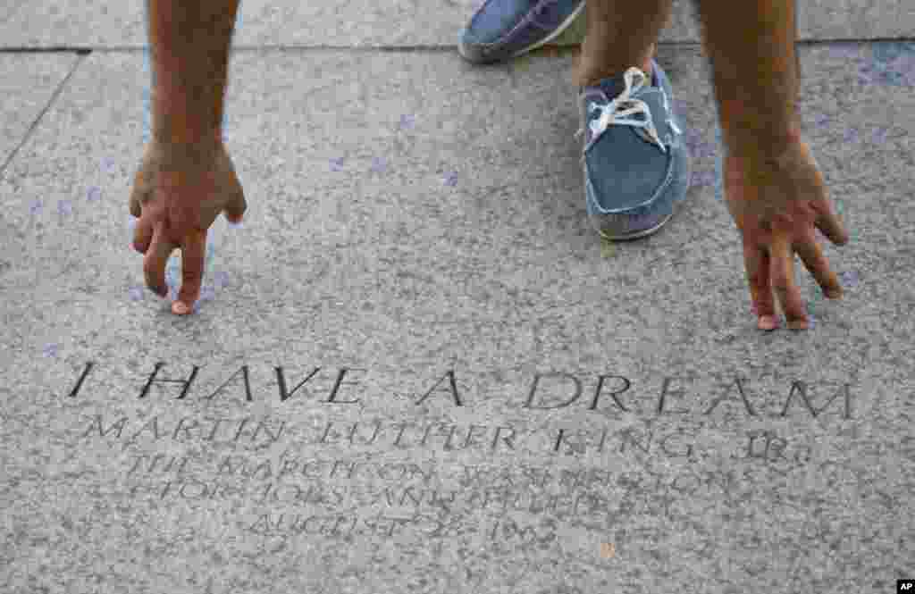 A tourist points to the exact location where Rev. Martin Luther King Jr., gave his famous 'I Have a Dream' speech, at the Lincoln Memorial in Washington, Aug. 22, 2013.