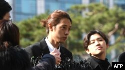 Bintang K-pop Jung Joon-young (tengah) berbicara kepada wartawan saat tiba di kantor Polisi Kota Seoul untuk penyidikan, Seoul, 14 Maret 2019. (Foto: AFP)