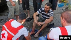 黎巴嫩紅十字會工作人員為受到火箭彈襲擊受傷得男子進行治療。
