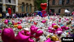 FILE - Flowers and tributes to the victims of the attack on Manchester Arena fill St Ann's Square in Manchester, Britain, May 29, 2017. Some are trying to scam free tickets to a benefit for the victims.
