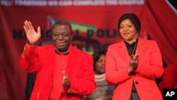 Zimbabwean Prime Minister and Movement for Democractic Change (MDC) President Morgan Tsvangirai, left, and his wife Elizabeth greet the audience on the first day of the party's National Policy Conference in Harare, May 17, 2013.