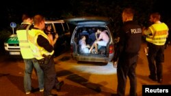 A group of migrants from Syria sits inside a vehicle stopped by German police on a country road heading to Freilassing, Germany, from Salzburg, Austria, Sept. 13, 2015.