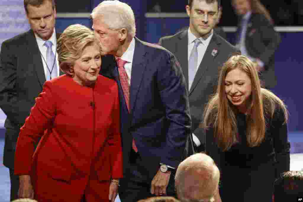 Former President Bill Clinton kisses Democratic presidential nominee Hillary Clinton as she and their daughter, Chelsea Clinton, greet supports during the presidential debate at Hofstra University in Hempstead, N.Y., Sept. 26, 2016. 