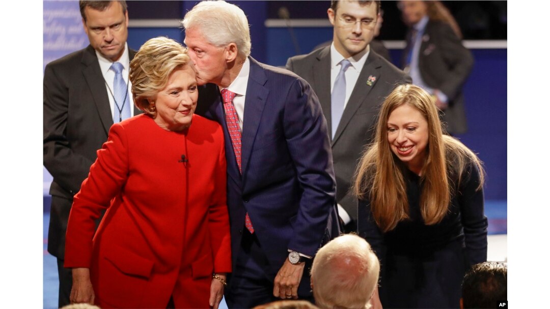 Former President Bill Clinton kisses Democratic presidential nominee Hillary Clinton as she and their daughter, Chelsea Clinton, greet supports during the presidential debate at Hofstra University in Hempstead, N.Y., Sept. 26, 2016.
