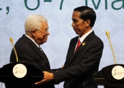 Presiden Joko Widodo (kanan) berjabat tangan dengan Presiden Palestina Mahmud Abbas (kiri) saat penutupan KTT Organisasi Kerja Sama Islam (OKI) ke-5 pada 7 Maret 2016 di Jakarta. (Foto: AFP/Garry Lotulung)