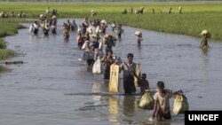 FILE - Rohingya refugees who have fled Myanmar’s Rakhine state, cross into Bangladesh at Palong Khali in the Cox’s Bazar district in this photo taken in mid-October 2017.
