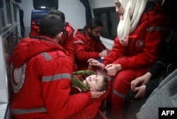 Syrian staff from the International Committee of the Red Cross evacuate a baby in Douma in the eastern Ghouta region on the outskirts of the capital Damascus.