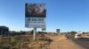 Cars and people pass a Zimbabwe Electoral Commission billboard in Harare, July 23, 2018, urging people to go and vote on July 30 and decide their future. (S. Mhofu/VOA)