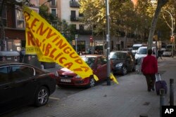 A woman walks past a torn down placard reading in Catalan "Welcome Republic" in Barcelona, Spain, Oct. 11, 2017.